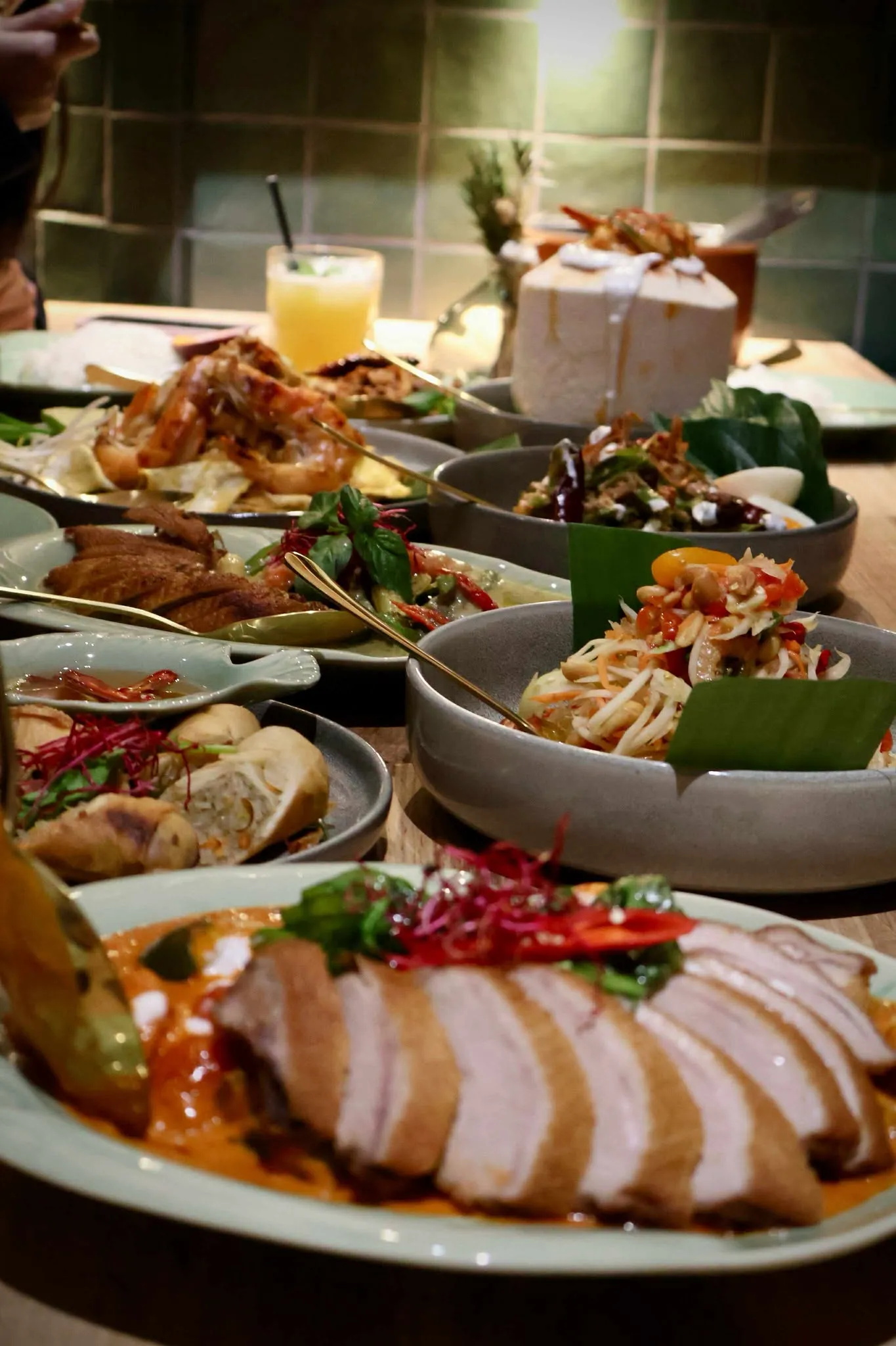 Reich gedeckter Tisch mit thailändischen Spezialitäten und Cocktails